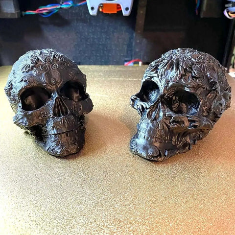 Two intricately designed skull models printed with ABS Plus 1.75mm Filament For 3D Printing, Built Tough With Low Warping, 1kg Black Spool