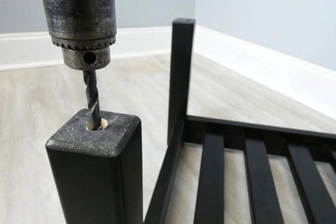 Drilling into furniture leg for 2 Inch Twin Wheel Office Chair Caster With Friction Stem Mount installation in black frame setting.