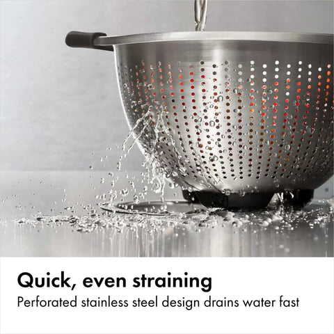 Non Slip Grip 5 Qt Stainless Steel Colander with Comfortable Handles for Pasta and Veggies straining water on counter