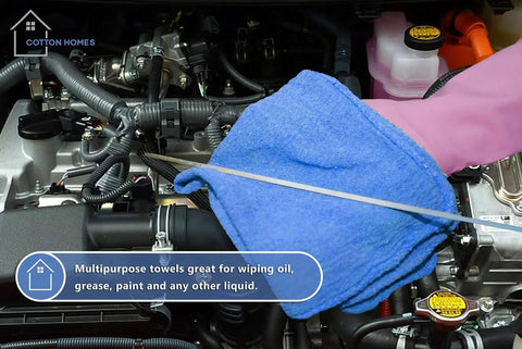 Person using Blue 12x14 Inch Shop Towels on car engine, 100 percent cotton, ideal for garage use as shown on packaging.