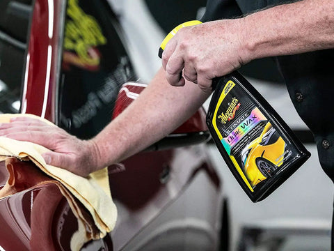 Person applying Ultimate Quik Wax With Hydrophobic Polymer Technology For Long Lasting Protection, Easy On And Off No Fuss, Superior Water Beading And Deep Wet Look Shine For Your Car, 709mL Meguiar's onto a car.