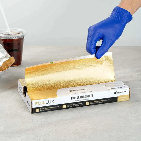 Gold Embossed Pop-Up Foil Sheets 10.8 X 9 Inch being extracted from box, ideal for fast service kitchens, keeps food warm on the go.