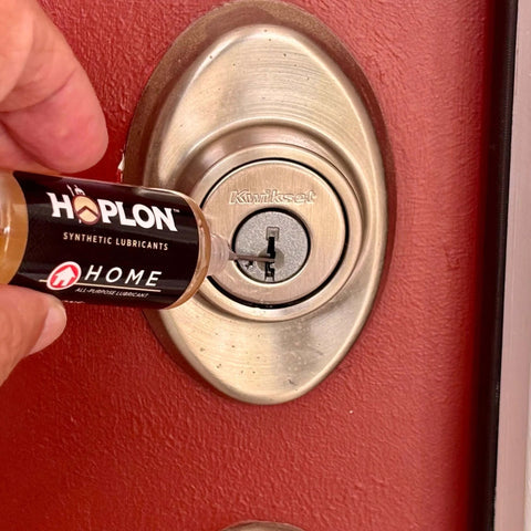 Applying All-In-One 5oz Synthetic Ester Lubricant Spray With Precision Needle to a door lock, showing detailed application.