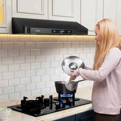 Woman cooking under 36 Inch Under Cabinet Range Hood With 900 CFM Dual Motors Black Kitchen Vent Hood For Real Heavy Duty Cooking