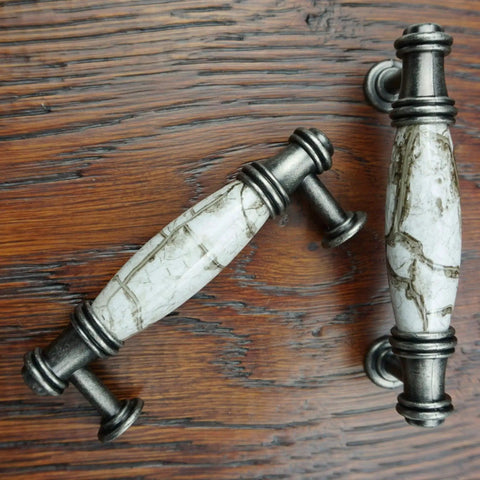 Antique-style metal and stone cabinet pull handles on wooden surface, not part of 10 Pack Silver Gray Cabinet Pulls With 3 Inch Hole Centers.