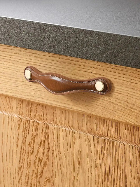 Installed brown leather drawer pull on wood cabinet with zinc alloy base, part of Leather Drawer Pulls 5 Pack, 5 Inch 128mm Leather Handles.