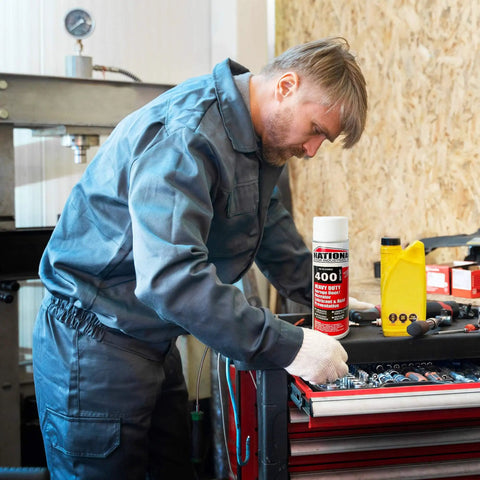 Man using Heavy Duty Garage Door Lubricant Spray With Rust Preventative And Long Lasting Hinge And Track Protection in workshop