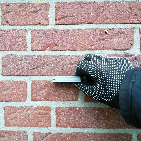 Hand holding spacer from Pro Grade Leveling And Spacing Shims Kit With 150 Pcs U Shaped Tile Spacers 1mm 2mm 3mm 4mm 5mm 6mm For Window And Door Installation And Woodworking By Left Bridge, installed between bricks