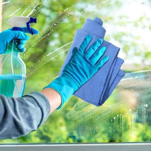 Cleaning a window with blue Huck towels, spray bottle in hand. Blue Huck Towels 50 Pack Bulk Absorbent Cotton Shop Towels