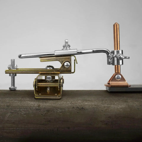 Deluxe Magnetic Grasshopper Welding Finger with copper spindle, V-pad base, and anti-tipping bolt on a rounded metal surface.
