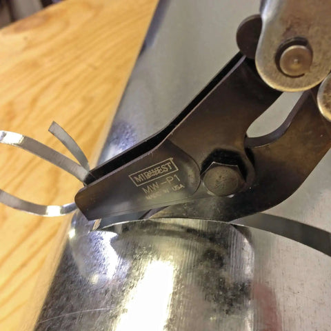 Pipe and Duct Cutter for One and a Quarter Inch Cuts with Cold Rolled Steel Construction cutting a metal duct, close-up view