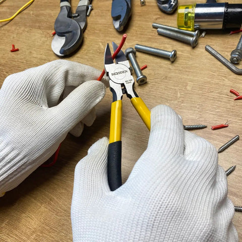 Hands using Ultra Sharp 6.5 Inch Wire Cutter For Jewelry Making And Crafting to cut red wire in a crafting workspace.