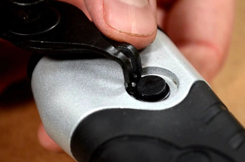 Close-up of snap ring pliers in use, part of the Beast Of A 10 Piece Snap Ring Pliers Set For Internal And External Rings With Heat Treated Chrome Molybdenum Steel And Comfortable Insulated Vinyl Handles Includes 10 Different Sized Pliers.