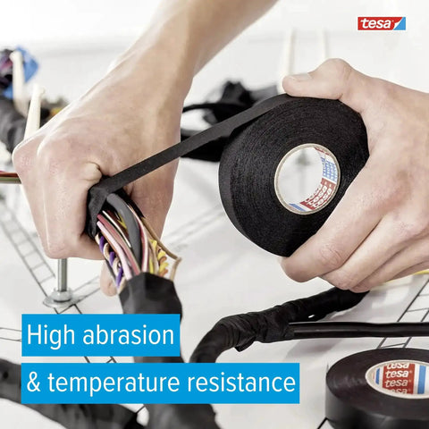 Hands wrapping wires with High Performance PET Cloth Automotive Wire Harness Tape Black 19mm x 25m 5 Rolls for protection.