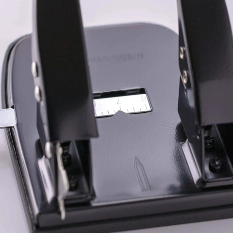 Close-up of Workhorse Two Hole Puncher For Paper With 30 Sheet Capacity Adjustable Guide And Locking Mechanism, black office tool.