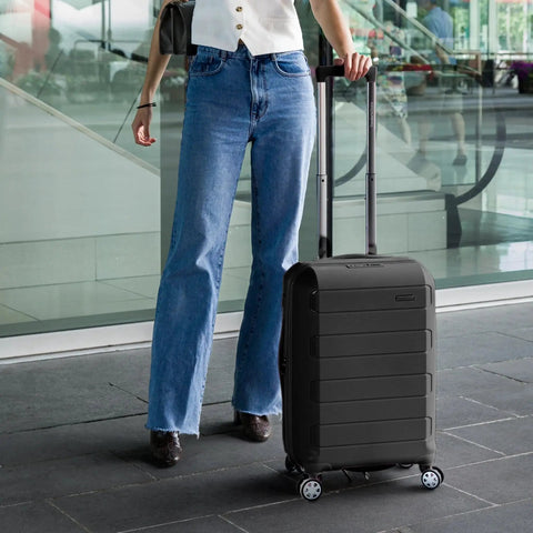 Person walking with Pagosa Hardside Carry-On Luggage With 2-Inch Expandable Gusset, Indestructible Polypropylene Shell, 22-Inch, Black