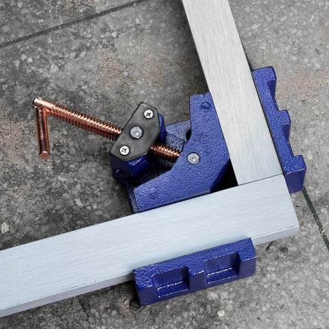 Heavy Duty Cast Iron Welder's Angle Clamp For Precise 90 Degree Joints on metal floor, two way swivel spindle visible