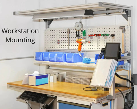 Workstation setup with organized tools and storage bins on a pegboard, featuring a clean work surface and mounted electronics.