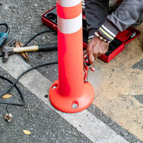 Person installing speed bump with Driveway Expansion Screws For Speed Bump Installation And Concrete Asphalt Anchoring.