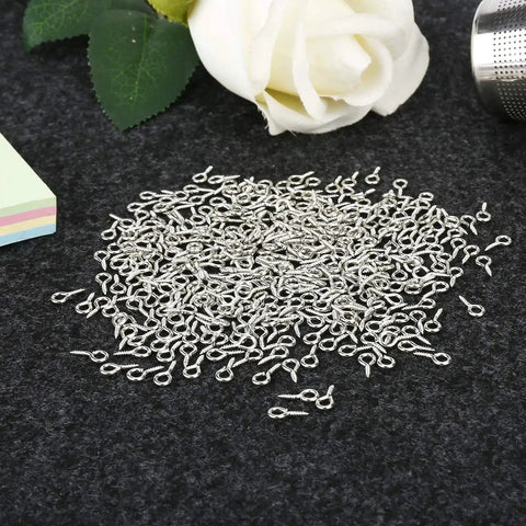500 Pieces 4 By 8 Millimeter Small Screw Eye Pins For Jewelry Making And DIY Art Projects on dark fabric