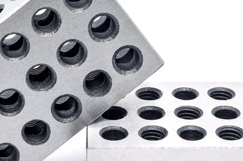 Close-up of precision ground 1 inch by 2 inch by 3 inch steel 1 2 3 blocks with 23 holes for setup layout and inspection.
