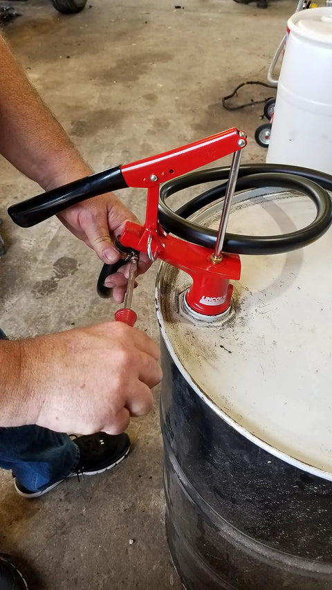 Lincoln 1335 Lever Action Fluid Transfer Pump for 16 to 55 Gallon Drums with 8.5 Fluid Ounces Per Stroke being used on a drum