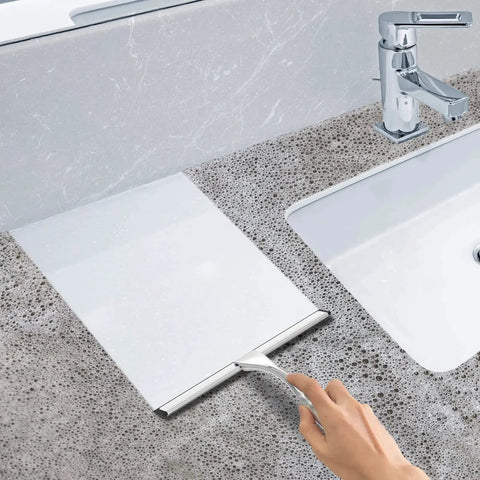 Stainless Steel Shower Squeegee 10 Inch With Adhesive Hooks For Glass being used on a wet countertop