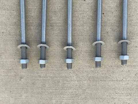 Five half inch by ten inch threaded concrete anchor L bolts with nuts and washers on concrete