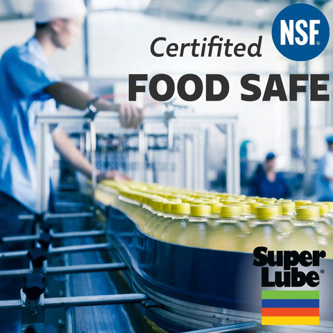 Factory worker with bottles labeled NSF and Super Lube on a production line, indicating food-safe certification.