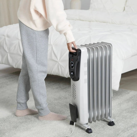 Person adjusting Cozy Up Fast With A Portable Oil Filled Radiator Heater From Amazon Basics With Three Heat Settings