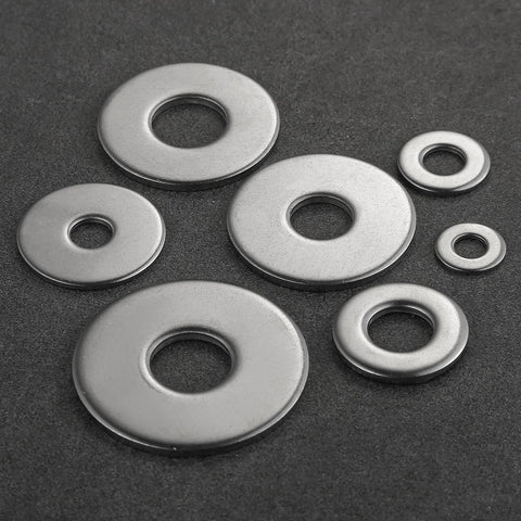 Assorted stainless steel flat washers, 304 grade, shown in several sizes for screws and bolts; top-view on dark background.