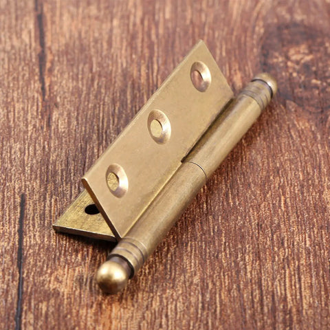 Antique brass hinge on wood surface, part of Dope Vintage Industrial Folding Butt Hinges For Cabinets And Boxes By Dophee, 2-pack.
