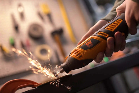 Powerful 1.3 Amp Variable Speed Rotary Tool With Steady Grip Handle in use on metal surface, emitting sparks in workshop.