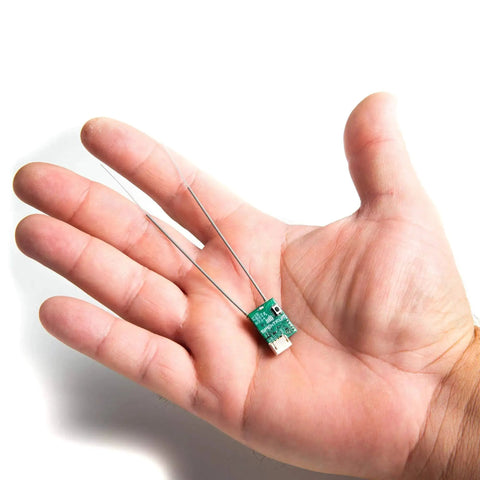 Hand holding Ultra Tiny SRXL2 DSMX Serial Micro Receiver For RC Gearheads, 2.4GHz DSMX Link With Smart G2 Capabilities, Model SPM4650.