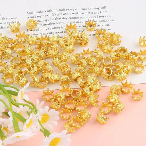 Gold Mini Crown Charms For DIY Jewelry Making 100Pcs Tiny King Crown Beads with 3D Alloy Spacers on a table