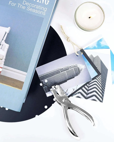 Two Piece Circle Hole Punch Set 1/8 Inch And 1/4 Inch Diameters for crafts next to book, candle, and photo tags