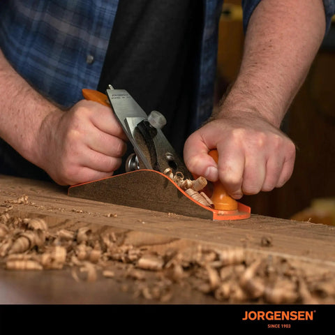 Person using Pro Grade 10 Inch Wood Plane For Smoothing And Trimming With A Durable Ductile Iron Body And Adjustable Cutting Depth O1 Tool Steel Blade Ready To Sharpen For Long Lasting Woodworking Projects Great For Professionals And Hobbyists Jorgensen No 4 on a wooden surface