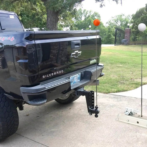 Two Pack Tall Adjustable Magnetic Trailer Alignment Kit With Extendable Poles For Boat Trailers, RVs, Campers, Horse Trailers And Cargo, Magnetic Hitch Line Up With Visible Red And White Balls, No Fuss Easy Height Adjustment installed with truck and trailer in driveway.