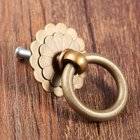 Vintage Style Brass Ring Pulls For Cabinets And Drawers, Round Cabinet Knobs and Drawer Handles on wood surface.