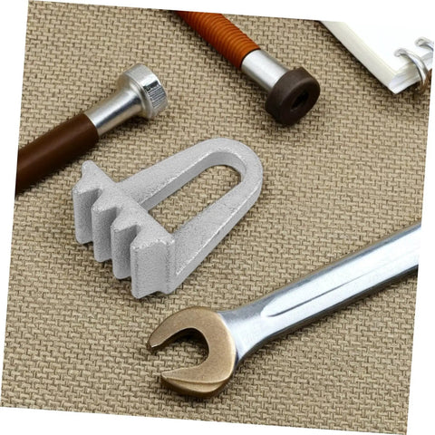 Front view of a silver engine flywheel lock assembly with a U-shaped body on a textured beige mat