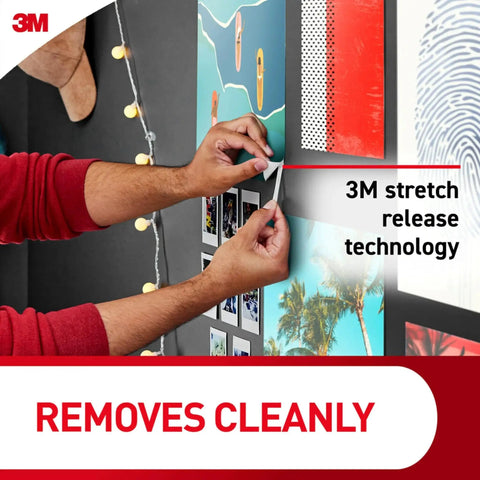 Person using Poster Strips 64 Count Damage Free Hanging Adhesive No Tools Hangs Up To 32 Posters Or Signs Removable From White Surfaces