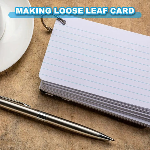 Stack of loose leaf cards bound with a ring, with a silver pen and cup, on a wooden surface, labeled "Making Loose Leaf Card".