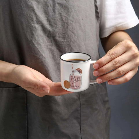 Person holding small ceramic espresso cup, possibly part of Four Pack Ceramic Demitasse Espresso Cups, 4.23 Oz Small Coffee Mugs for Espresso Machines and Home Coffee Makers, Microwave and Dishwasher Safe, Great for That Quick Caffeine Fix.