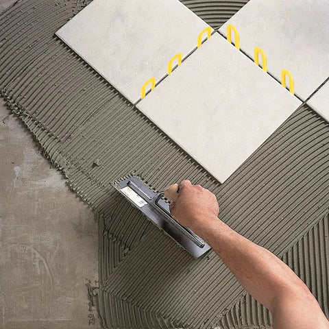 Horseshoe Shims Kit Color Coded U Shaped Plastic Leveling Shims 2x1.3in used for tile leveling on gray mortar bed.