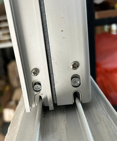 Close-up of 304 Stainless Steel Pan Head Phillips Machine Screws 1/4-20 x 2 Inches securing door frame, showcasing installation use.