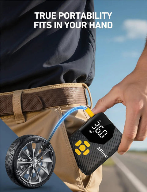 Close-up of Compact Portable Tire Inflator For Cars Bikes And Balls With 150 PSI Pump Built In Tire Pressure Gauge And LED Light Ultra Quick Inflation For Car Truck Motorcycle And Bike AstroAI L7 Mini in hand near a tire.