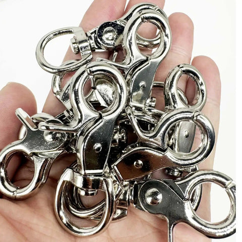 Hand holding several Lobster Clasp Trigger Snap Hooks 360 Degree Swivel Zinc Alloy 30 Pack, showing silver hooks.
