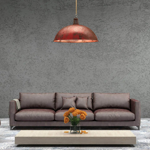 Modern living room with brown couch, orange pendant lamp, and vase of orange flowers on a marble coffee table.