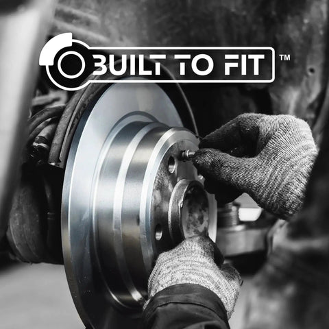 Centric C-Tek front brake rotor being installed on a vehicle; silver metal disc with central hub, gloved hands.