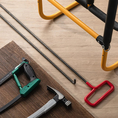 Two 33-inch steel rebar lifter hooks on a wooden floor with other construction tools nearby.